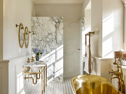 A luxurious victorian style bathroom with slab shower and gold finish on bath tub