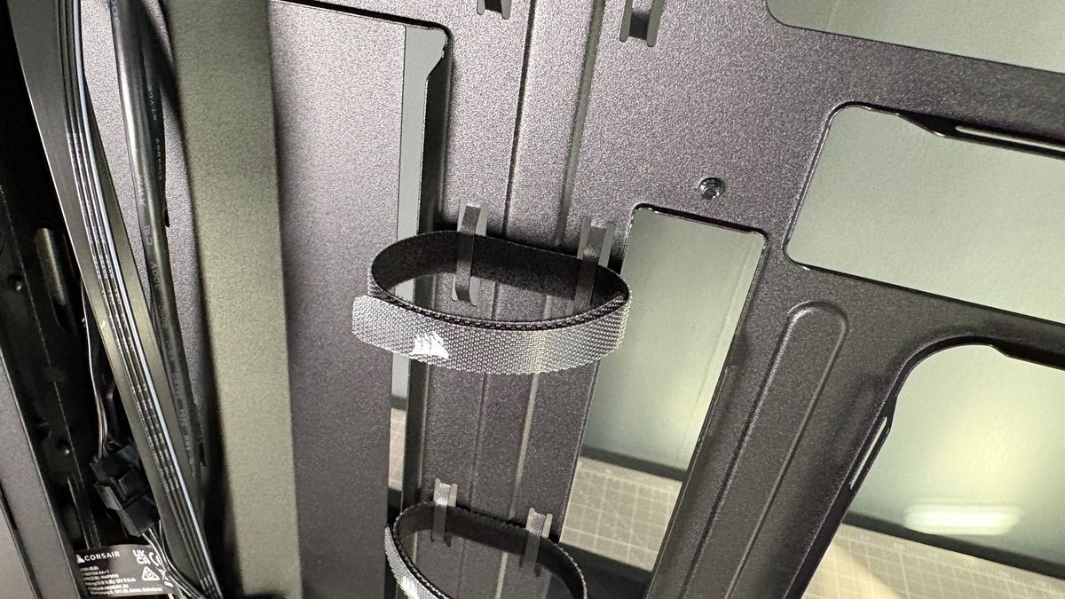 A Corsair PC case, the 3200D, on a desk with various panels removed and ready for a PC build.