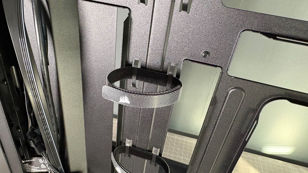 A Corsair PC case, the 3200D, on a desk with various panels removed and ready for a PC build.