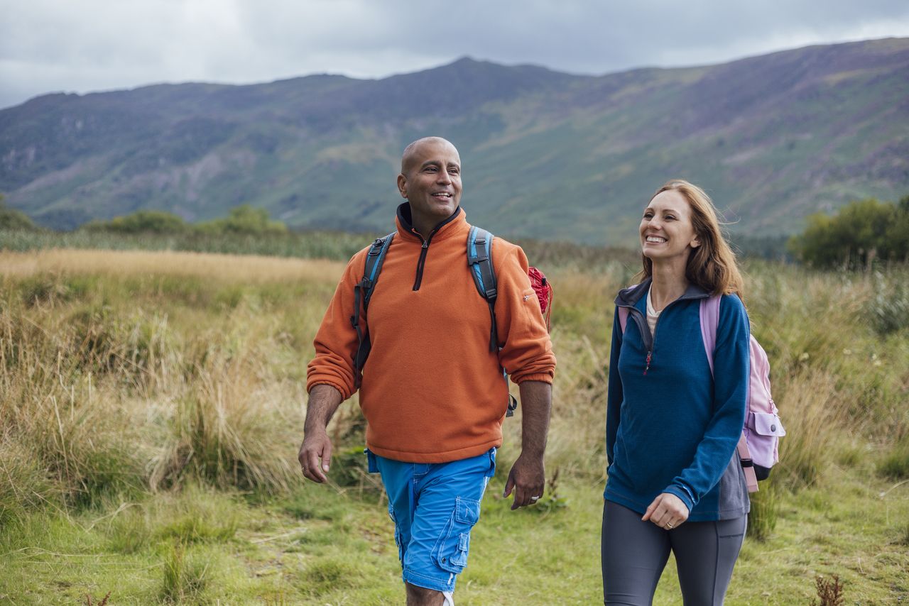 Couple smile as they enjoy a walk in the countryside in the Lake District