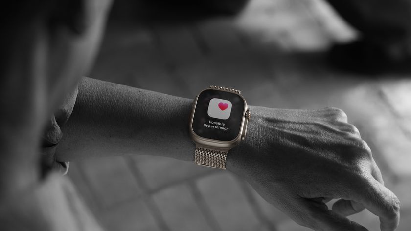 A mostly black-and-white photo of a person wearing the Apple Watch Ultra 3 — with a gold case — with a &quot;Possible Hypertension&quot; pop-up shown in full color.