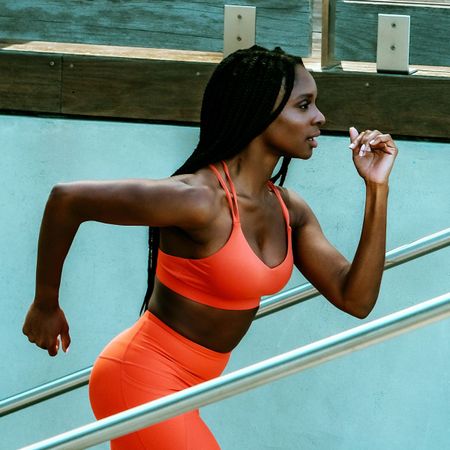 Best sports bras: woman wearing red matching set bra and leggings