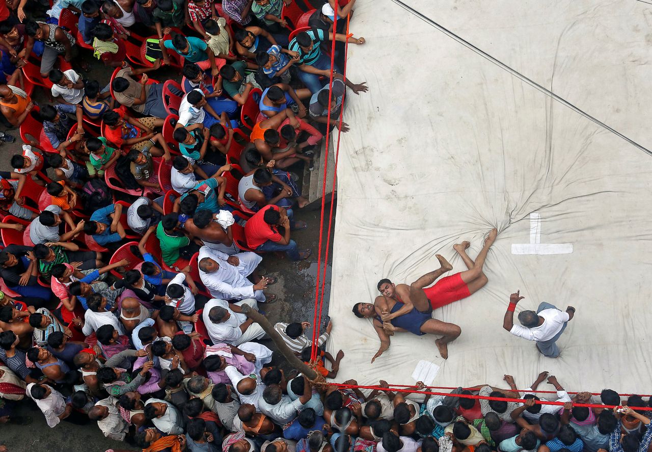 Wrestlers fight during an amateur wrestling match inside a makeshift ring organized by local residents as part of the celebrations for the annual Hindu festival of Diwali in Kolkata, India.