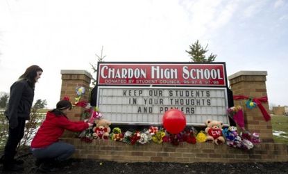 Two students place flowers on a makeshift memorial at Chardon High School, where T.J. Lane allegedly opened fire on his fellow students, killing three.