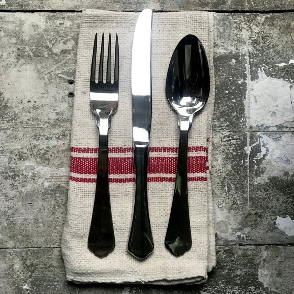 Set of stainless steel flatware on a linen napkin