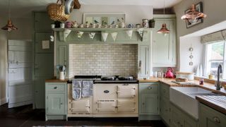 farmhouse kitchen with cream Aga and pale blue kitchen units
