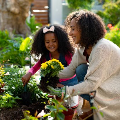 Woman and daughter planting garden