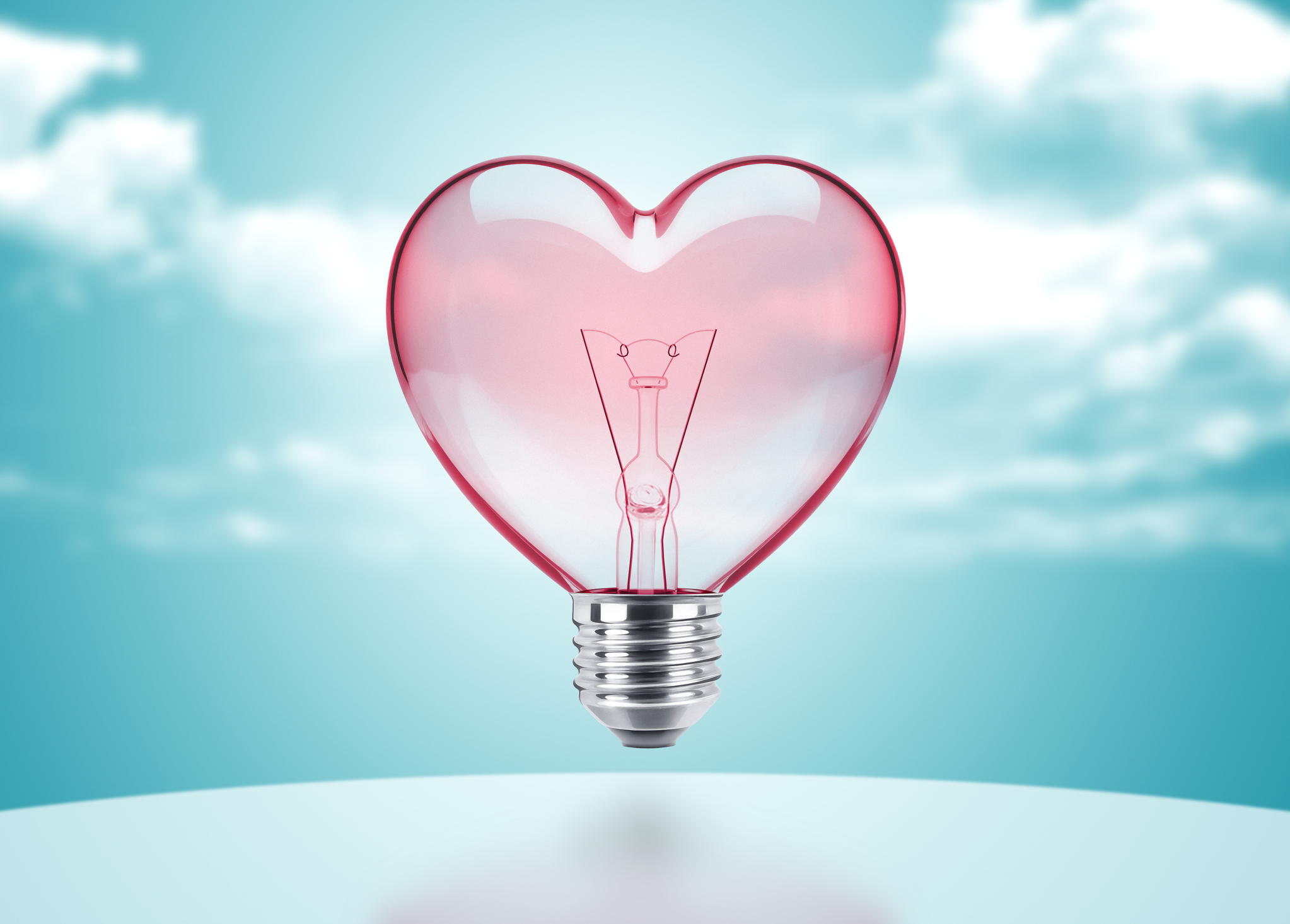 Heart-shaped light bulb on a surreal background. Digital Composite