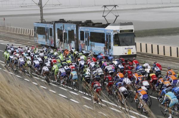 The peloton passes a tram at Gent-Wevlegem