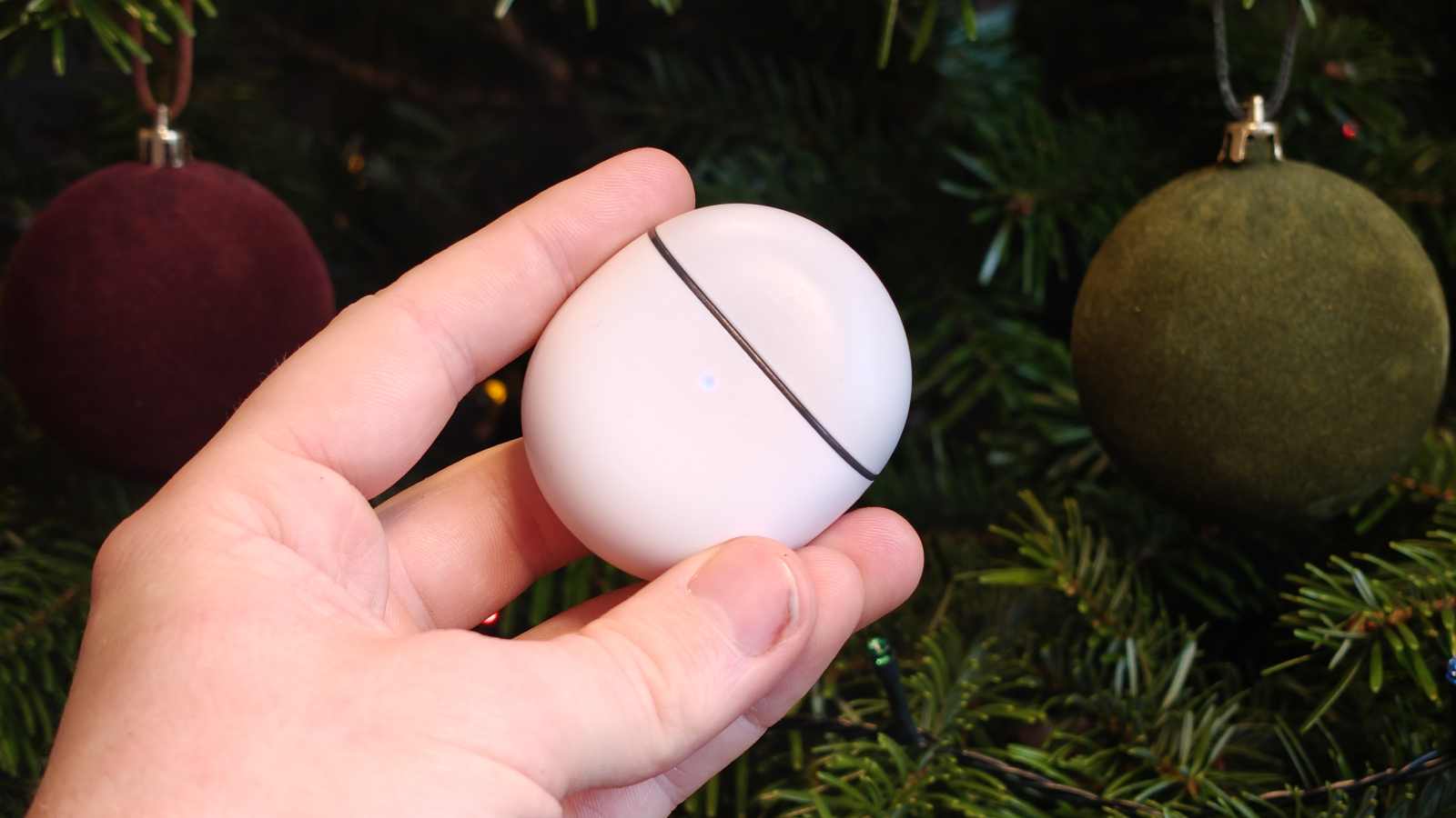 The Google Pixel Buds 2a case in a man's hand.