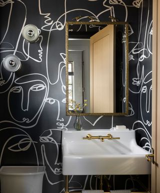 powder room with basin and black wallpaper with white face design