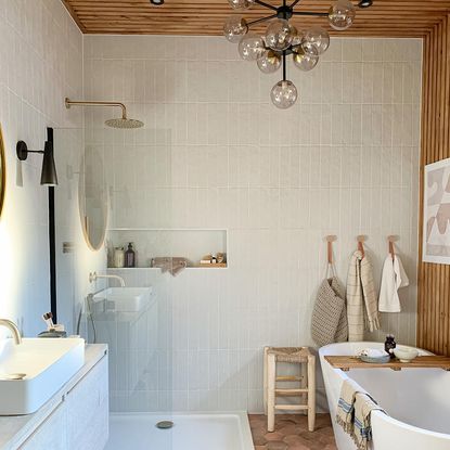bathroom with white tile wall bathtub and wooden ceiling