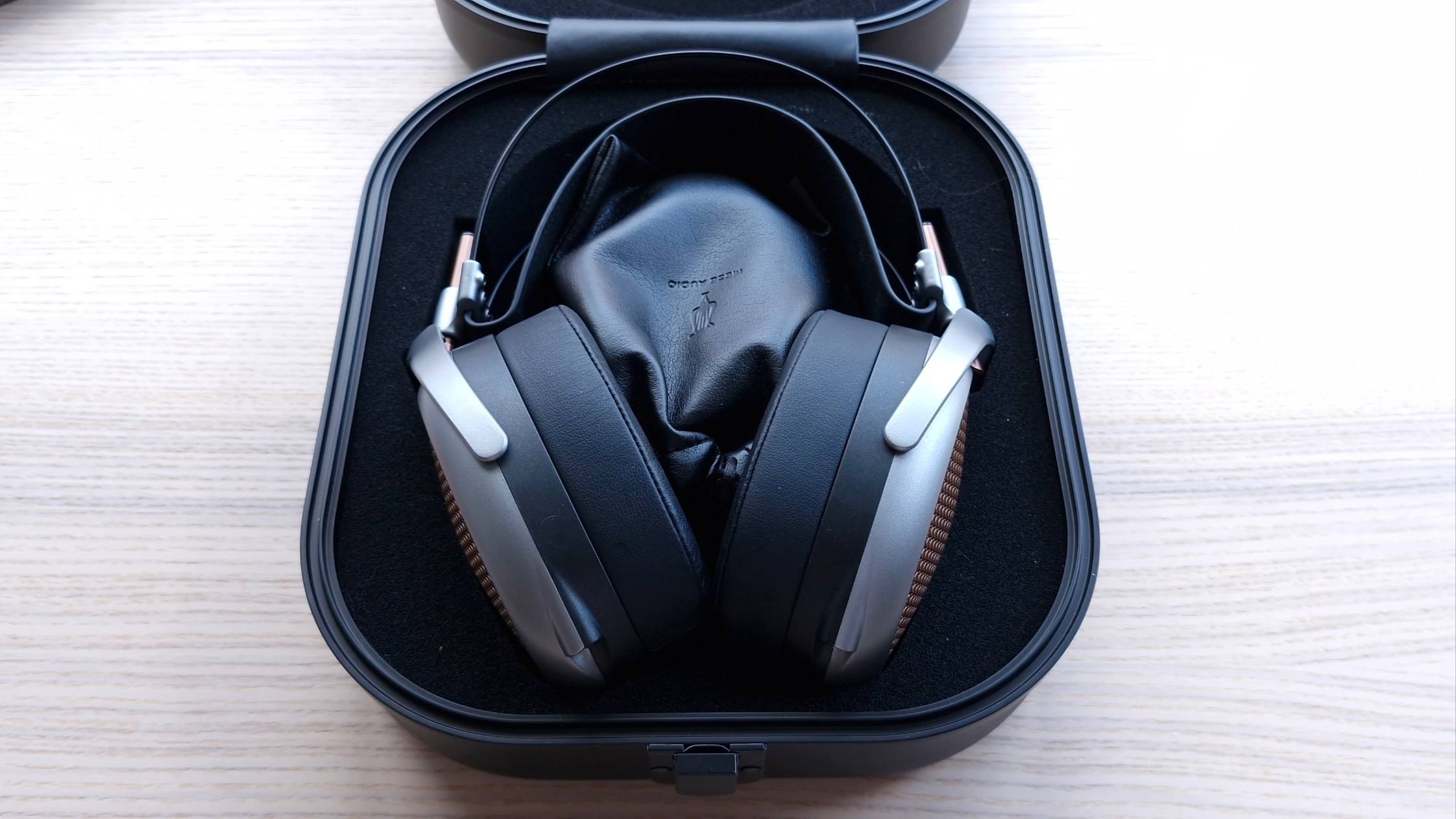 Carry case of the Meze Audio Poet over-ear open-back headphones, on a wooden surface