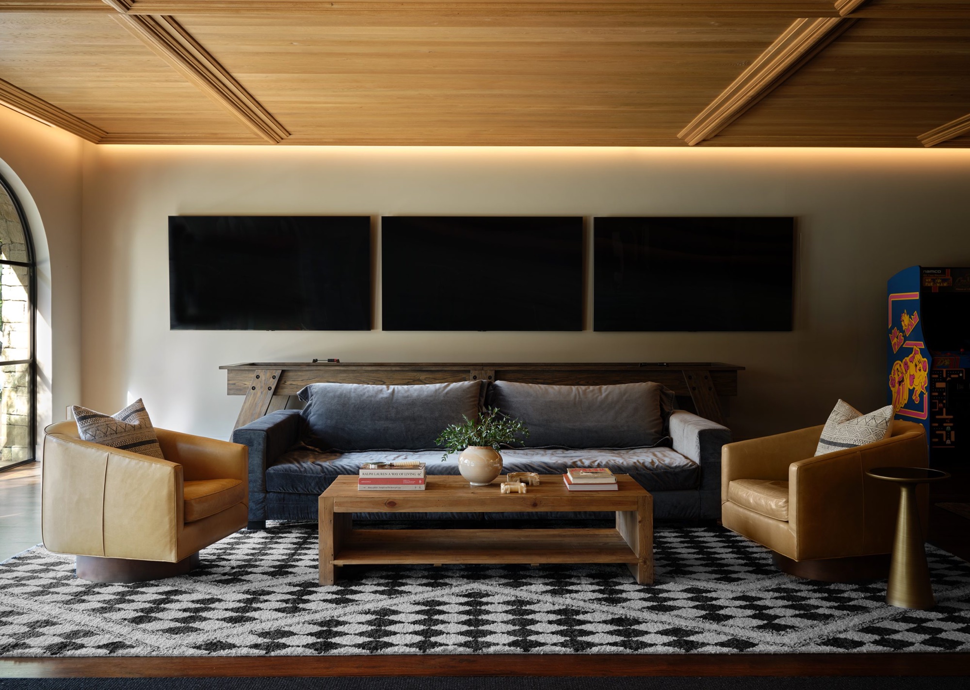 Games room and family room with wall wash lighting by Ryan Street with a sofa in the middle as well as chairs on each side