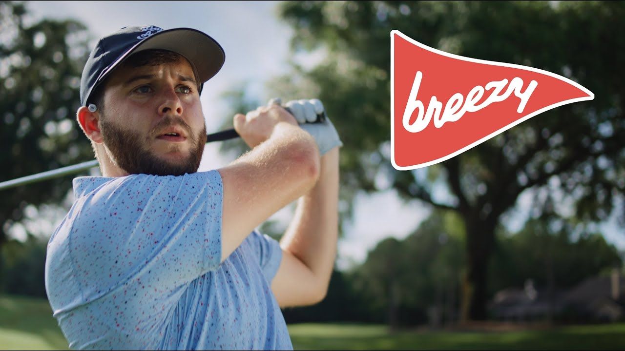 A golfer wearing Breezy Golf apparel takes a swing