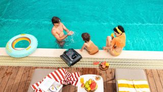 A family relaxes poolside with their Aiper robot pool cleaner