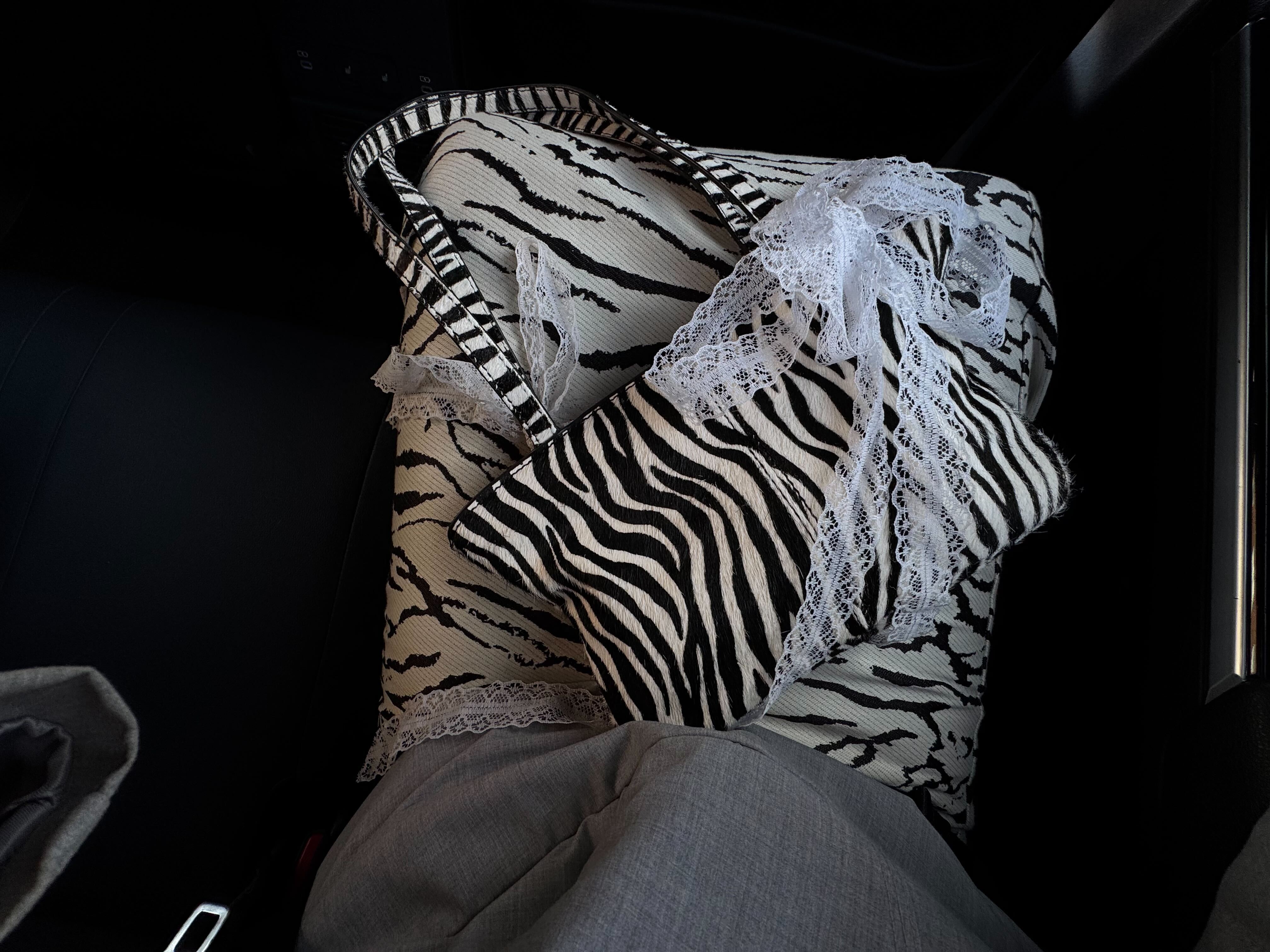 @rebeccarhysevans wears a zebra print bag with a zebra print skirt and a grey top.