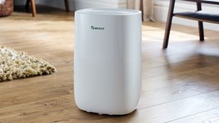 A Meaco dehumidifier on a wooden floor in a living space