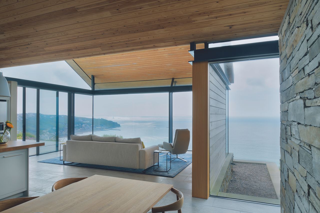 glass extension with modern living room looking out to sea