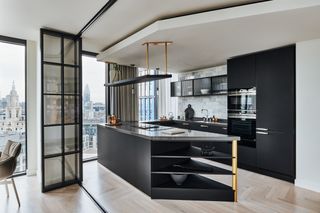 Open plan kitchen with internal bi-fold doors with black frame