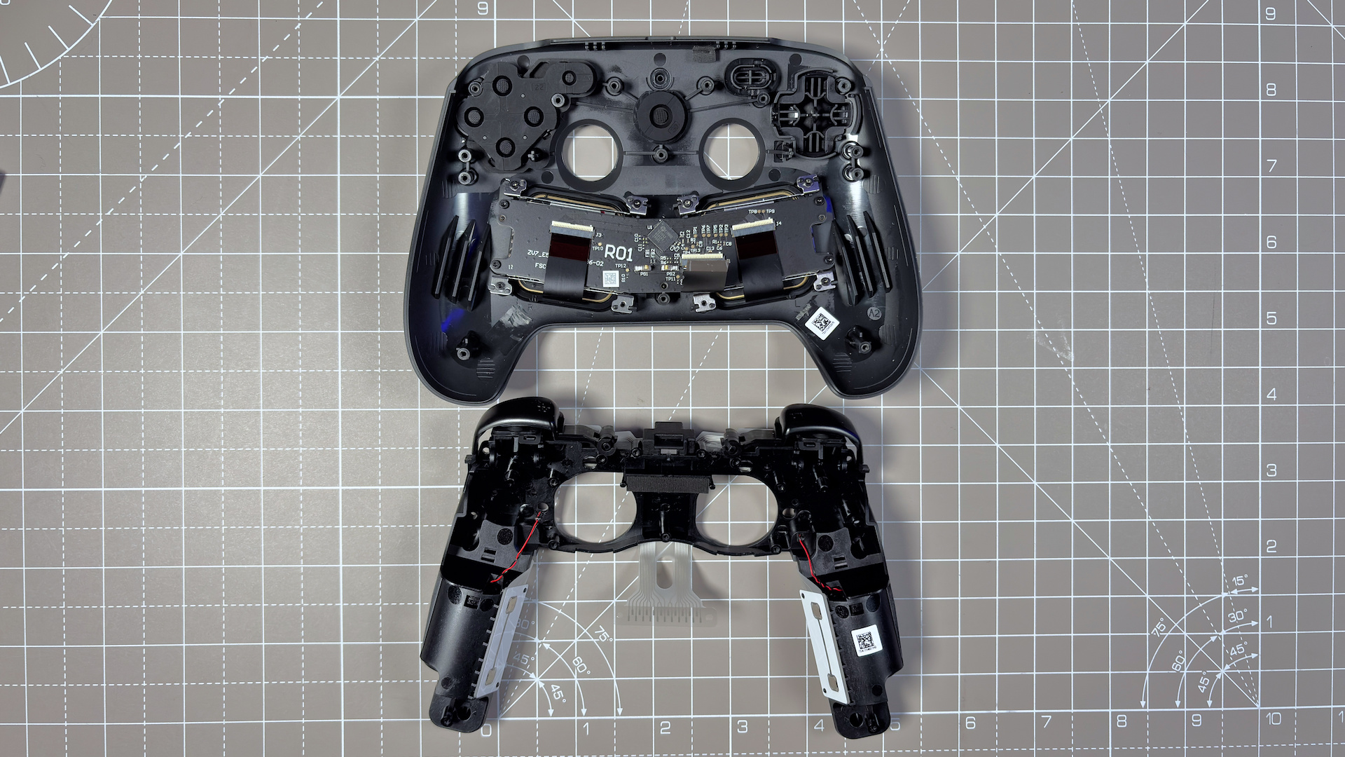 The Steam Controller on a desk during a teardown, with various parts removed.