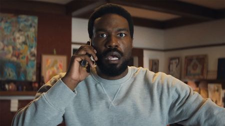 Simon Williams looking shocked as he listens to someone during a mobile phone call in Marvel's Wonder Man