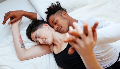 High Angle View Of Couple Lying On Bed At Home