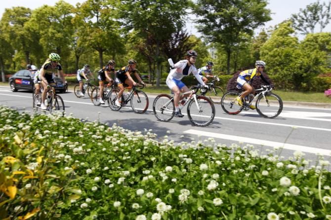 Breakaway over, Eun Hee Kim (Korea), asks for a fresh bidon from the team car