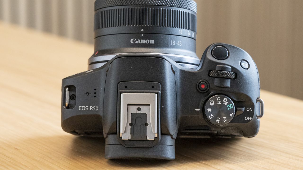 Top of Canon EOS R50 on a table with all of top panel