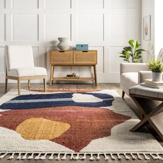 This rug has a natural base with abstract patches of cream, blue, brown, yellow. It