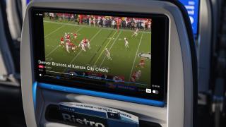 United airlines seat showing NFL football game.