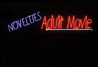 Neon adult video sign at night.