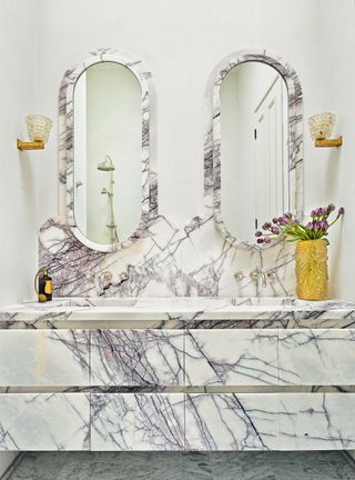 Marble bathroom with curved mirrors and vanity