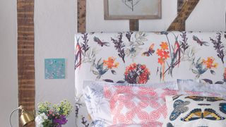 floral fabric headboard with colourful cusions