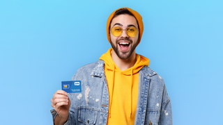 white hipster man in yellow hoodie holding a Tello SIM card