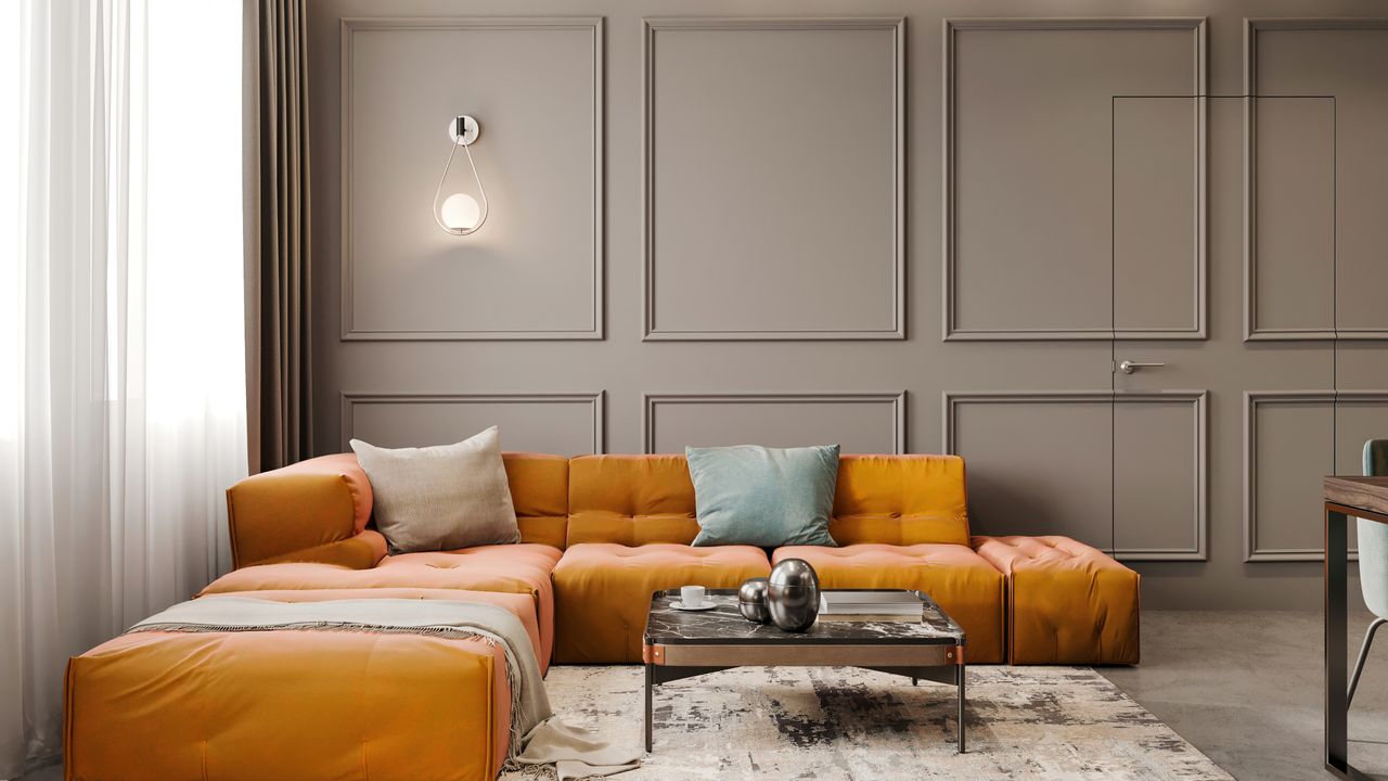 Grey painted living with panel moulding feature wall effect, yellow sofa with cushions