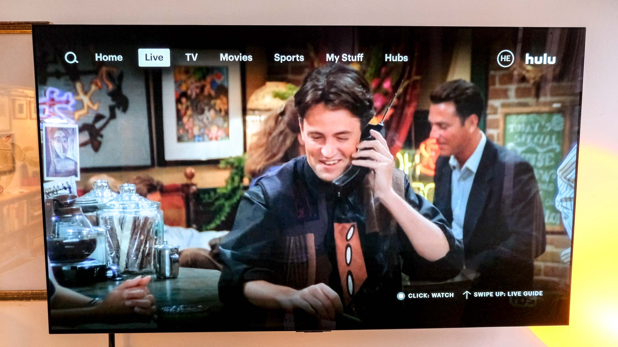 Chandler (Matthew Perry) is on the phone in Friends, playing on Hulu + Live TV