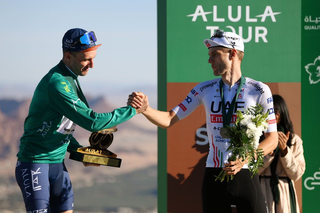 Simon Yates shakes hands with Finn Fisher-Black after the 2024 AlUla Tour