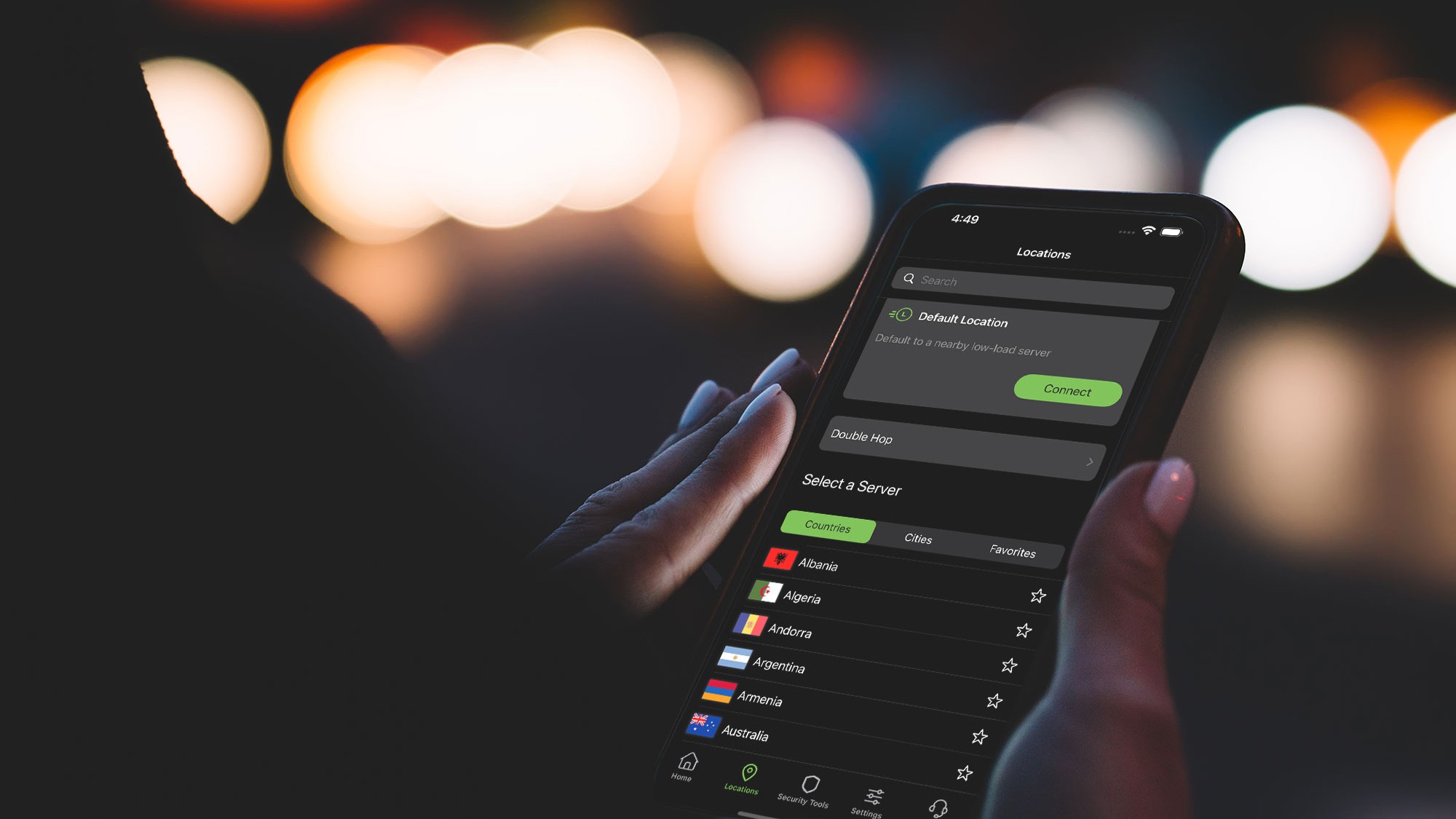 Woman holding a smartphone with the IPVanish VPN app open on the server location tab