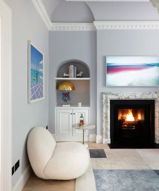 white living room with curved white sofa, neutral rug and fireplace