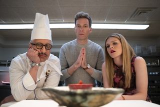 Bronson Pinchot as Didier Gotthard, Barrett Foa as Elliot Morgan, Molly Griggs as Lilly Schumacher in a kitchen looking at a dish in the residence