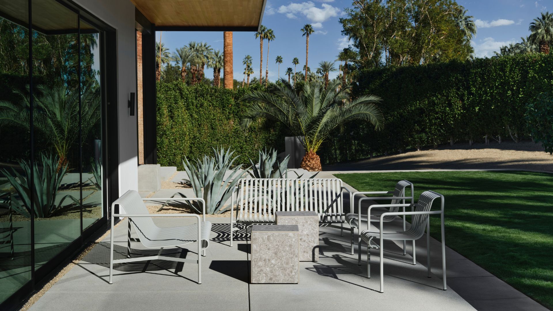 A backyard with neutral outdoor furniture and blocked side tables