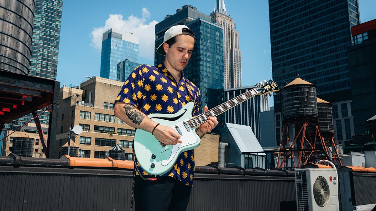 Giacomo Turra playing his signature D&#039;Angelico guitar on an NYC rooftop