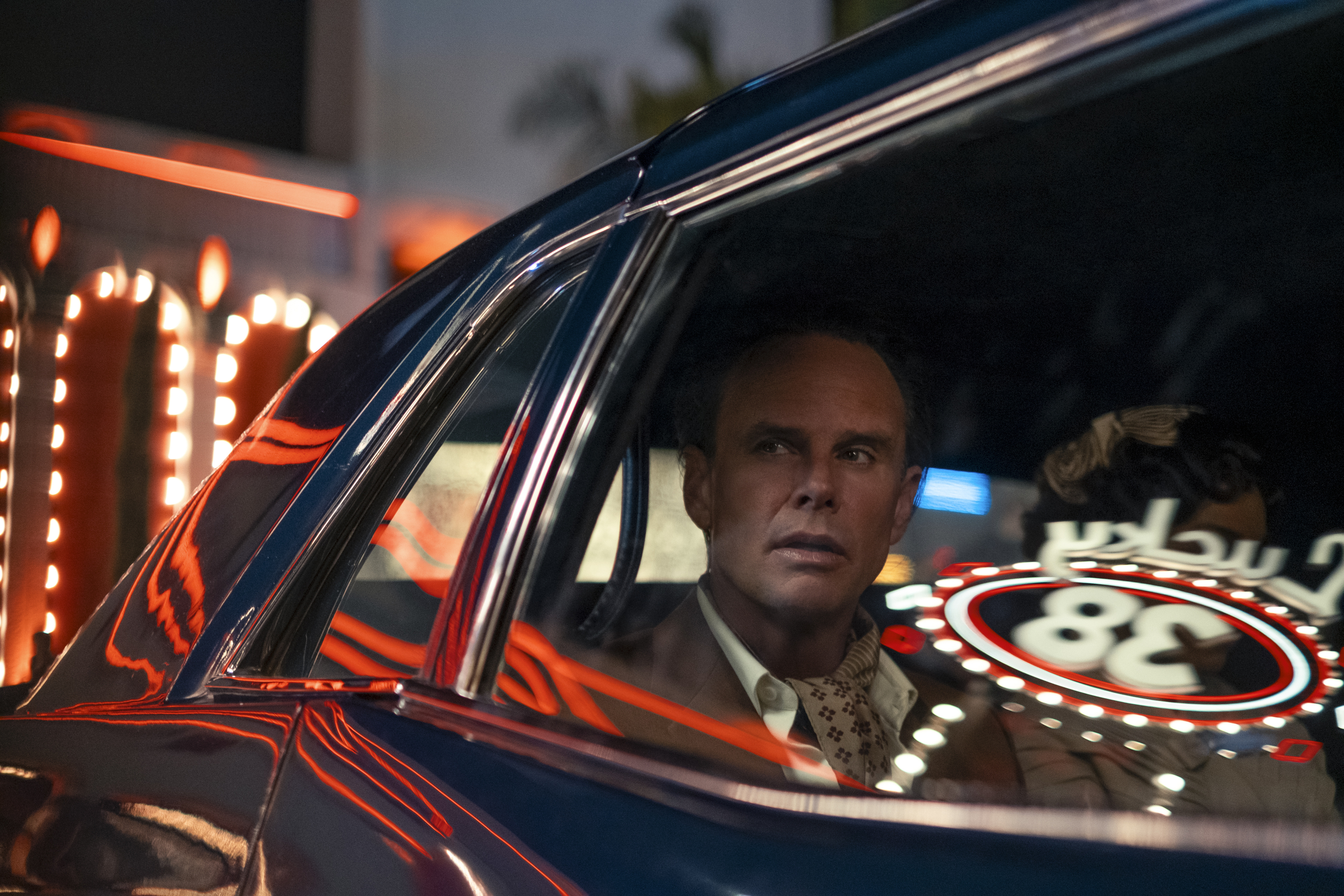 Walton Goggins in a car with the window reflecting the Lucky 38 casino