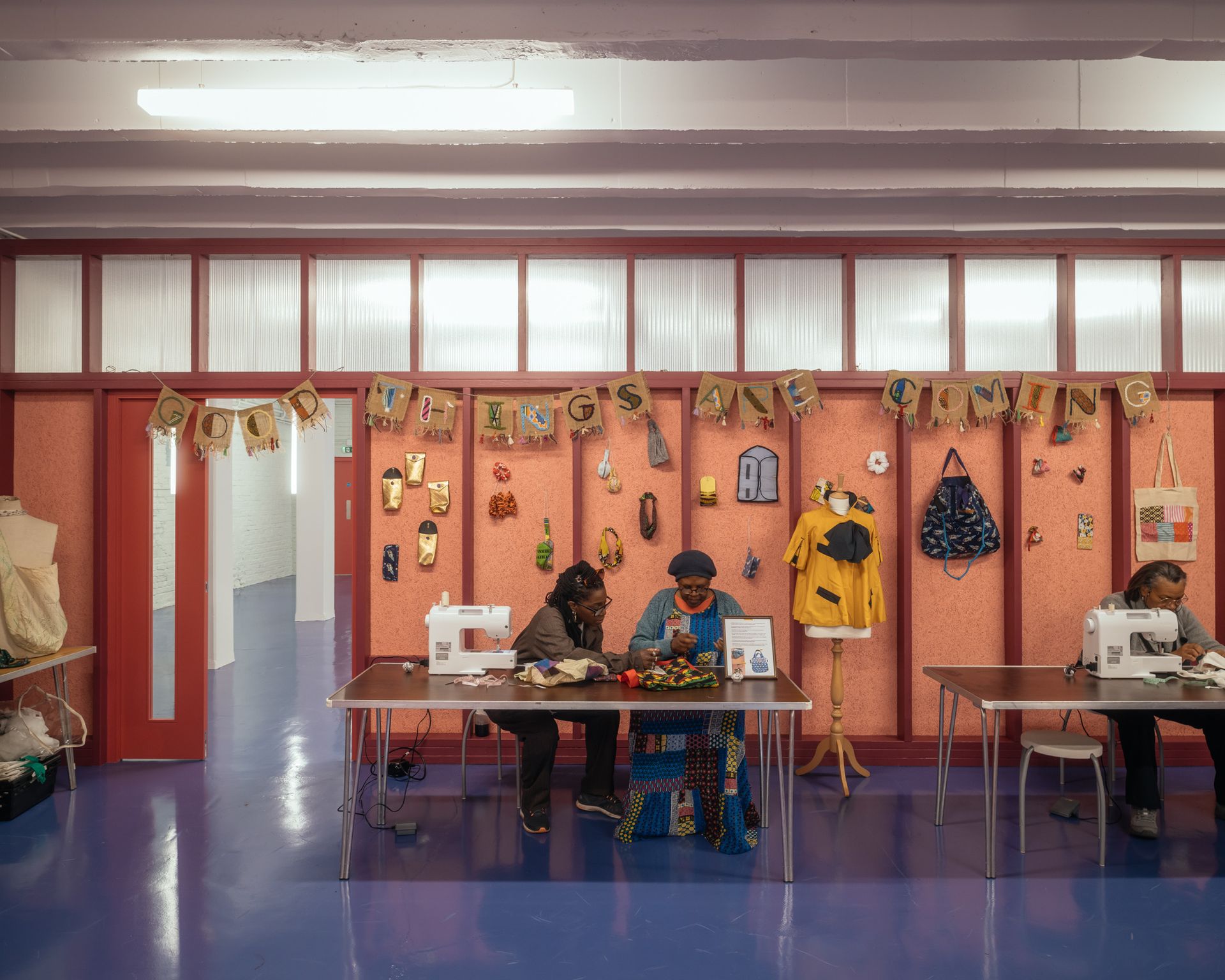 The Common Rooms interior with two people sat chatting against red walls