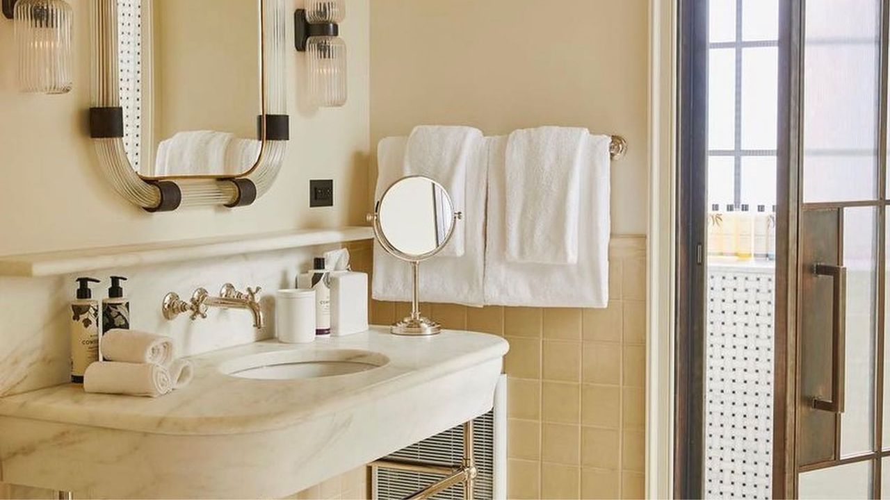 an off white bathroom stocked with towels and toiletries