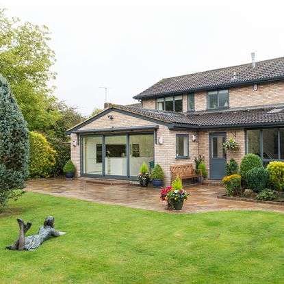 sloping roof house with grass lawn and garden