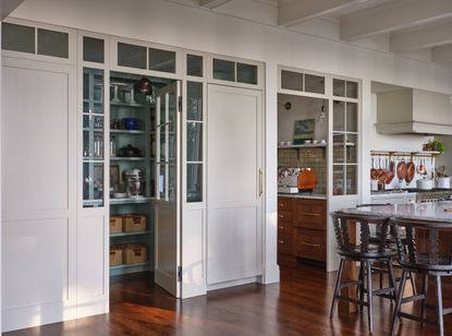 a white kitchen with a small colorful pantry