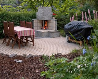 Outdoor fireplace and bbq decked area in a backyard