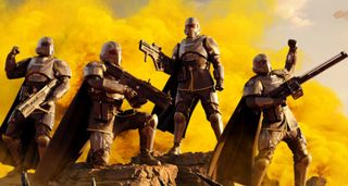 A quarter of Helldivers pose triumphantly after killing a Terminid foe.